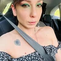 Sarah Slave porn actress in a car wearing her seat belt taking a selfie.