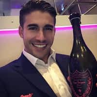 Adrian Dimas porn star in suit having a bottle of champagne at a club.