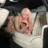Harleen Van Hynten porn actress bent over in all fours in a car backseat, wearing skimpy black underwear.