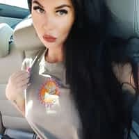 Alice Alisaki porn actress in the backseat of a car, holding her hair back and pouting her lips.