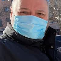 Torbe pornstar wearing a blue mask and north face coat, with a river in the background.