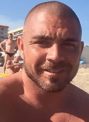 Chris Dark pornstar at the beach smiling.