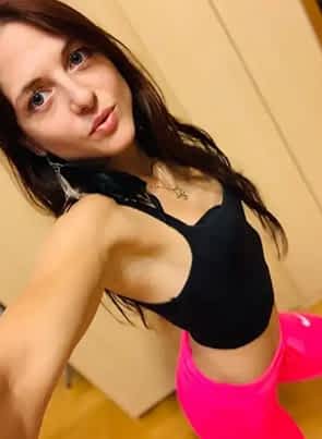 Rachel Adjani pornstar in black tanktop and pink shorts posing while pouting her lips.