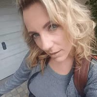 Mya Lorenn porn star taking a selfie outside a garage wearing gray shirt and jacket.