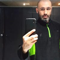 Nico porn actor in black gym jacket, taking a selfie in front of the mirror.