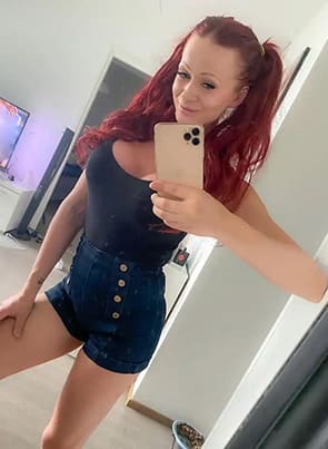 Cindy Sun posing in front of the mirror taking a selfie in her livingroom.