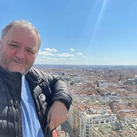 Torbe male pornstar taking a selfie and showing the view of a city in the background.