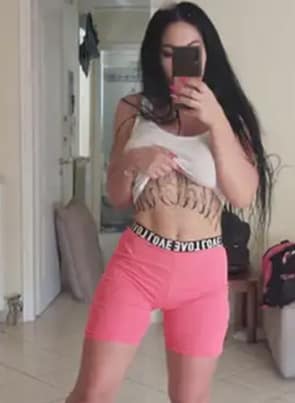 Alice Alisaki taking a selfie in her sportswear, lifting her shirt to show her underboob tattoo.