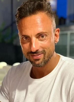 Andrew Milan pornstar smiling in white shirt.